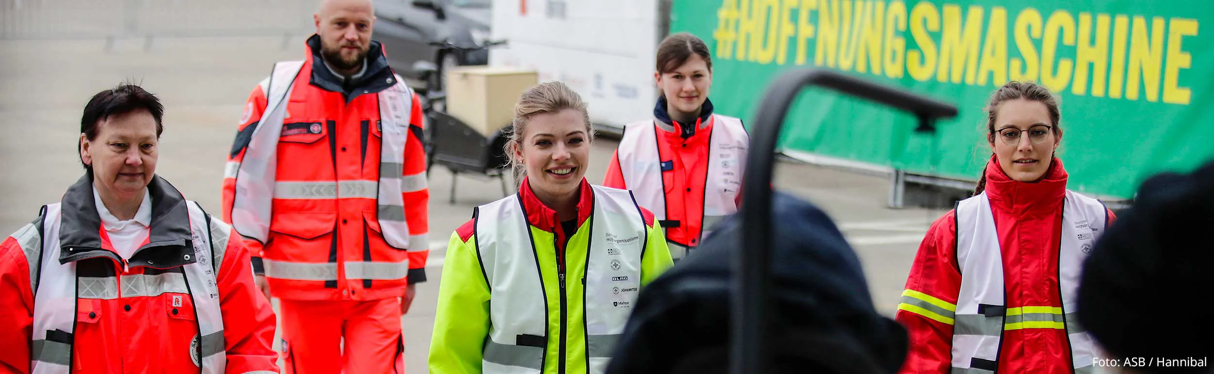 Helfer:innen der Berliner Hilfsorganisationen gehen auf Kameramann zu.