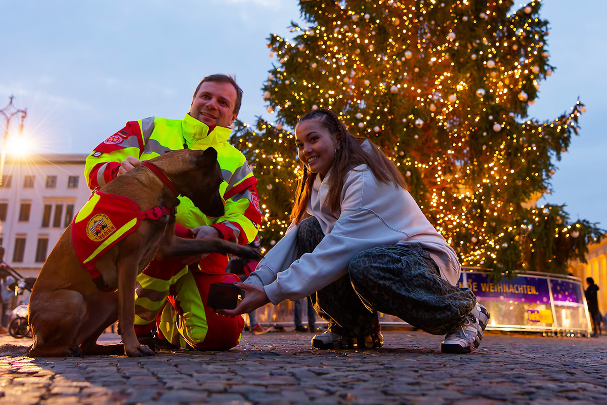 Rettungshundeteam knipst die Lichter am Weihnachtsbaum vor dem Brandenburger Tor an