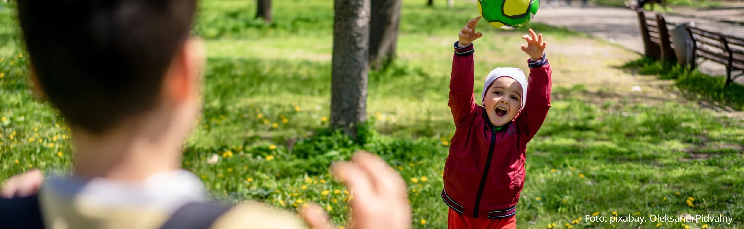 zwei Kinder, die mit einem Ball spielen