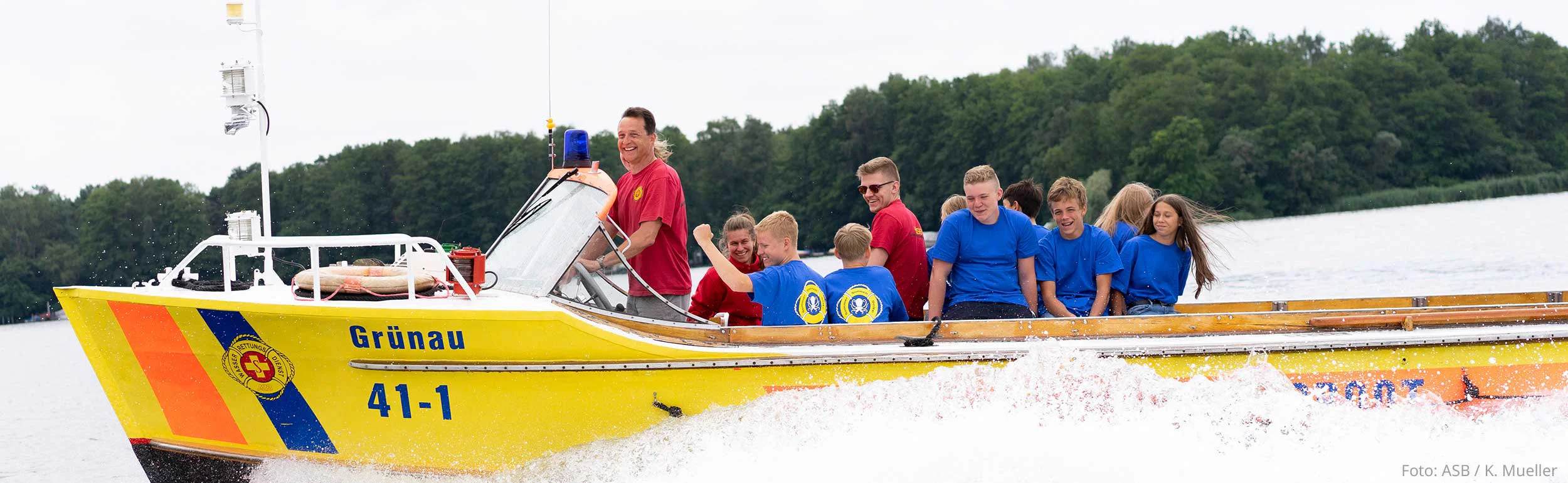 Gruppe von Kindern und Jugendlichen im Rettungsboot auf dem See