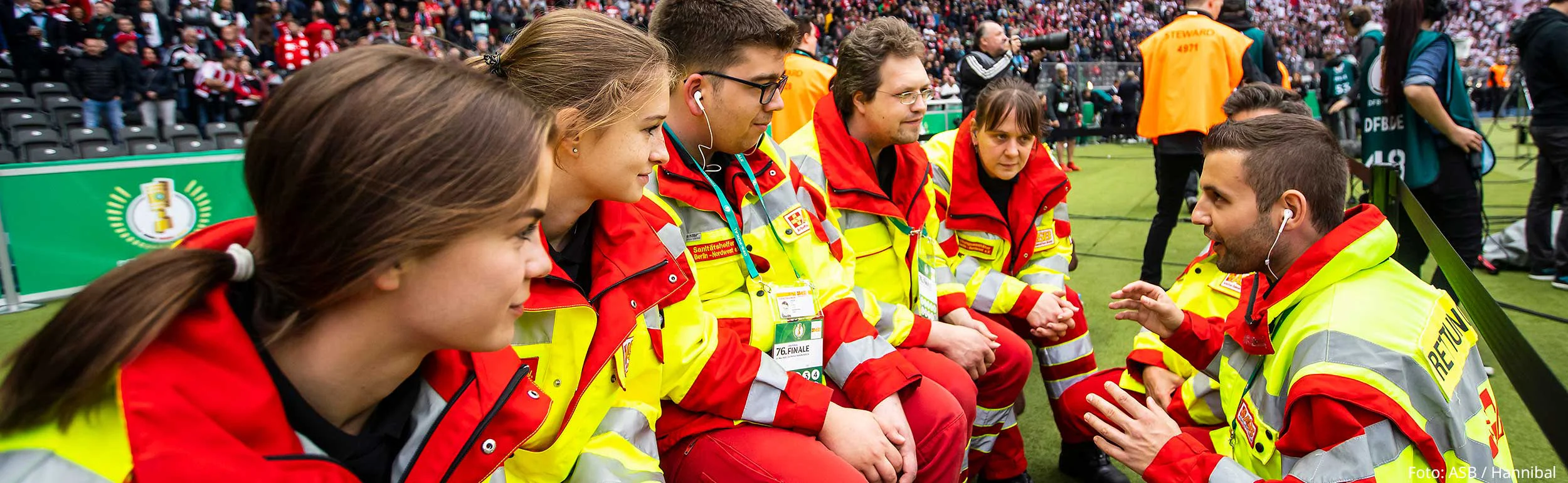 Einsatzbesprechung von sechs Sanitäter:innen im Olympiastadion