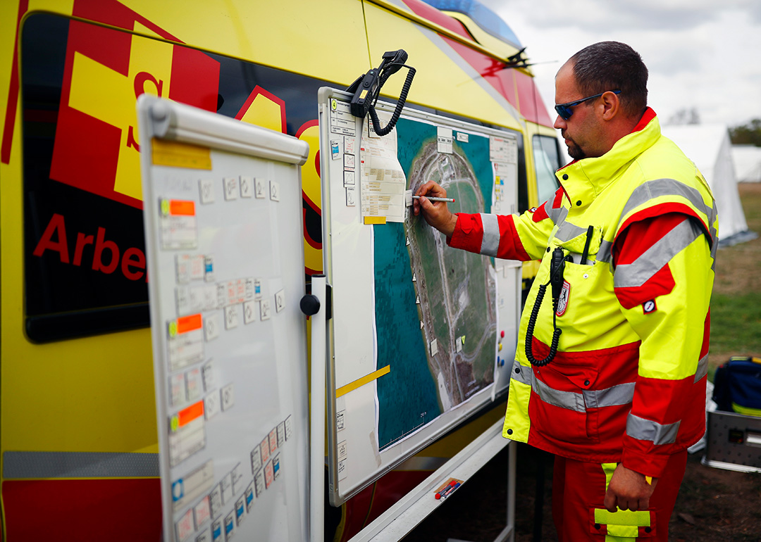 Unsere-Angebote_Katastrophenschutz_FMDI_20180922asb65_c-ASB-Hannibal.jpg Samariter in Einsatzkleidung zeichnet eine Position auf dem Lageplan ein.